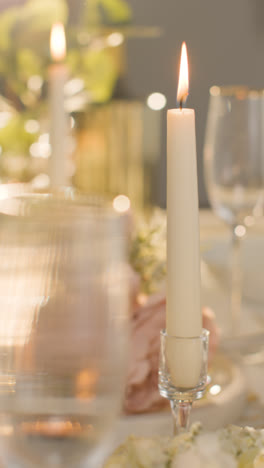 Vertical-Video-Close-Up-Of-Candles-And-Glasses-On-Vertical-Video-Of-Table-Set-For-Meal-At-Wedding-Reception-Or-Restaurant